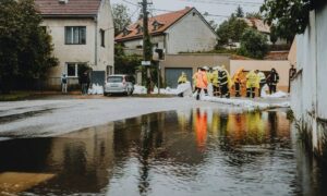 Residents and emergency workers placing sandbags to protect homes from flooding in Oklahoma City, highlighting the importance of an elevation certificate for flood risk assessment.