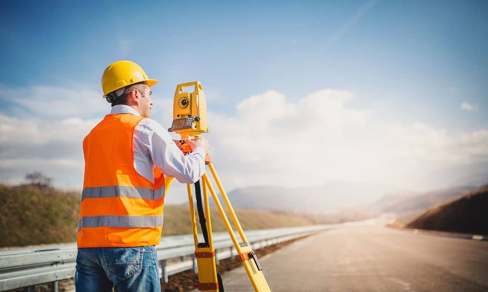Licensed land surveyor conducting a topographic survey with a total station in Oklahoma City.

