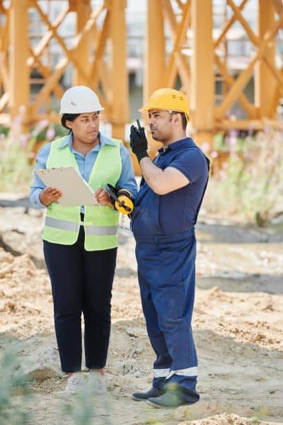 Engineers discussing boundary survey site - ALTA SURVEY Oklahoma Two engineers discussing boundary survey details at a construction site.