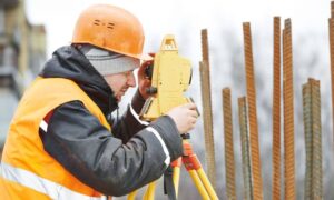 Surveyor using a total station to check property markers after an earthquake