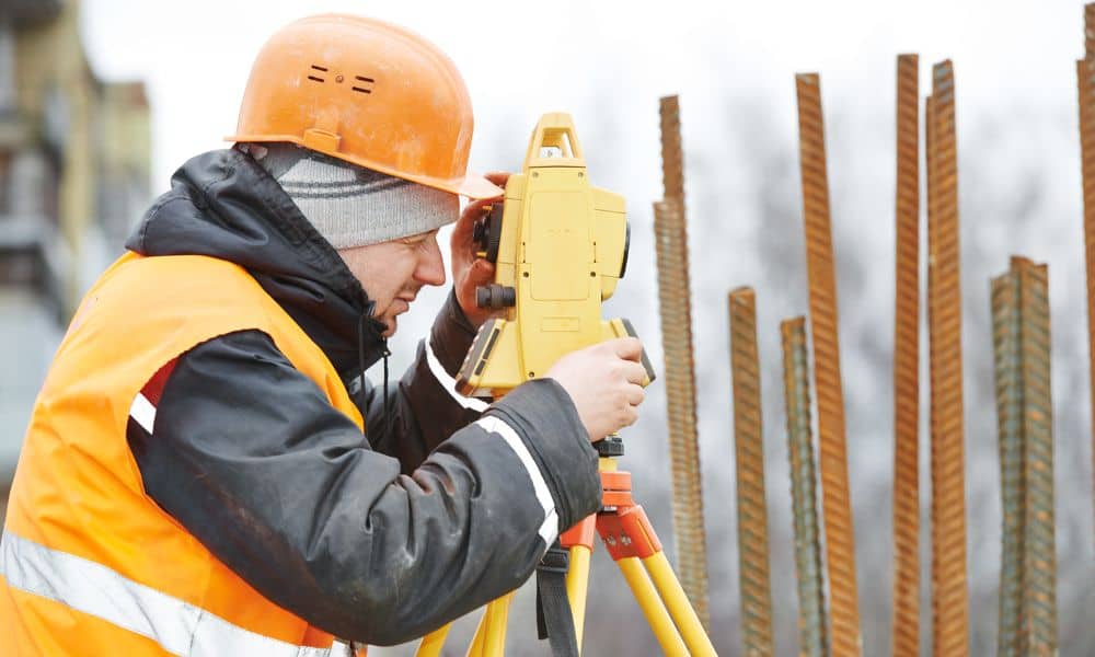 Surveyor using a total station to check property markers after an earthquake