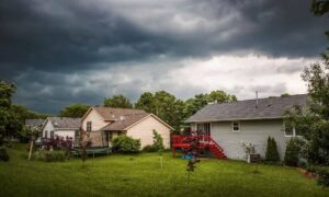 Suburban homes under dark storm clouds showing risk of flooding and importance of checking flood elevation certificate