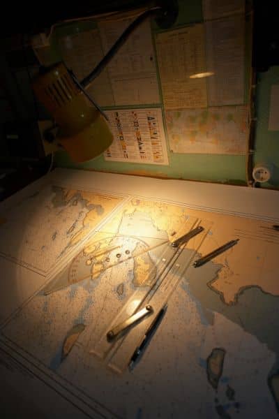 Technical map and measuring tools on a desk, used to review land records during a property line survey.