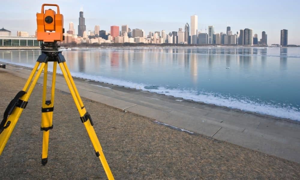 Surveyor measuring riverbank - ALTA SURVEY Oklahoma Surveyor conducting a boundary survey along a riverbank to mark property lines
