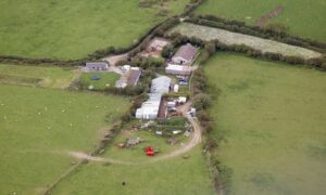 Rural farmstead with a farmhouse, barn, and sheds on a property surveyed by a residential surveyor